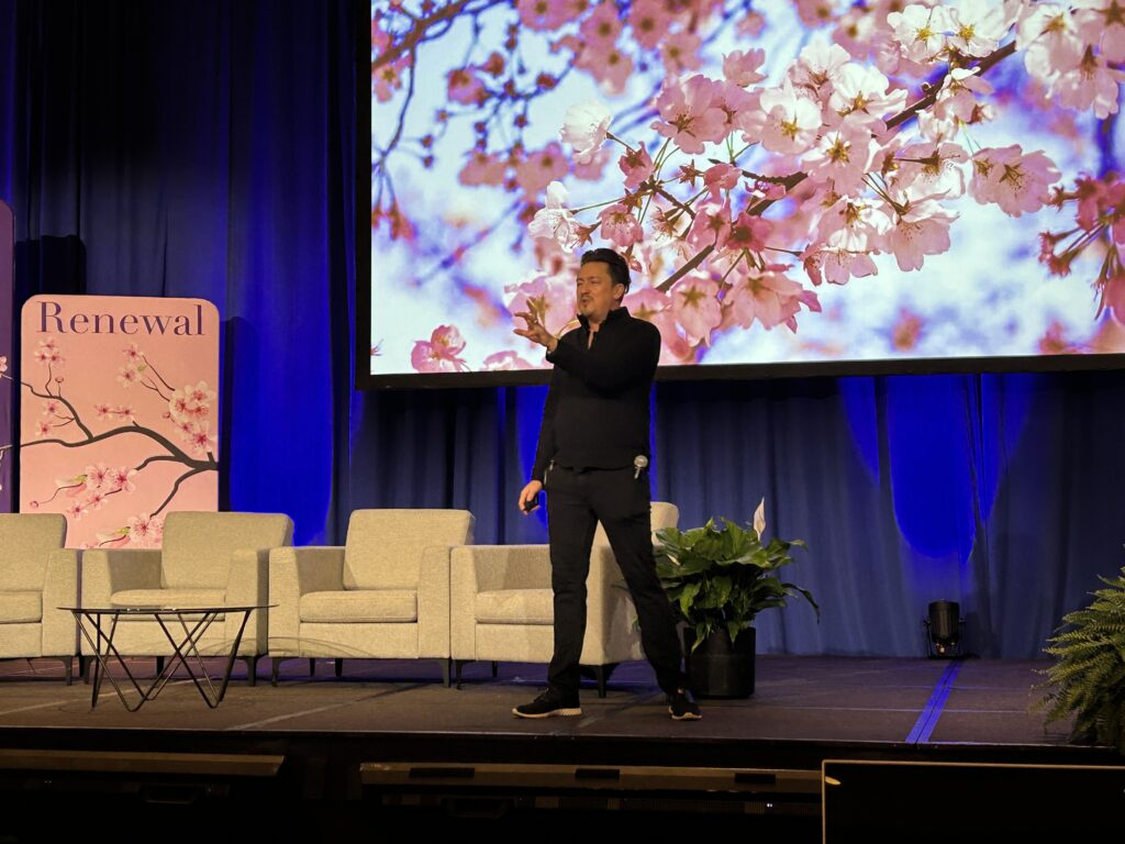a man (mike ganino) is on stage speaking at an event